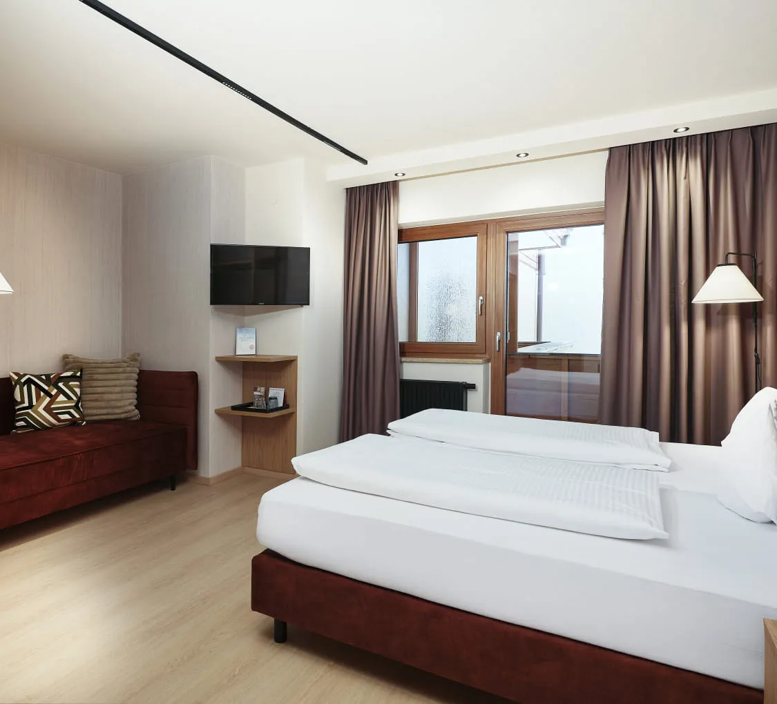 Doppelzimmer mit zwei Betten und gemütlicher Sitzecke