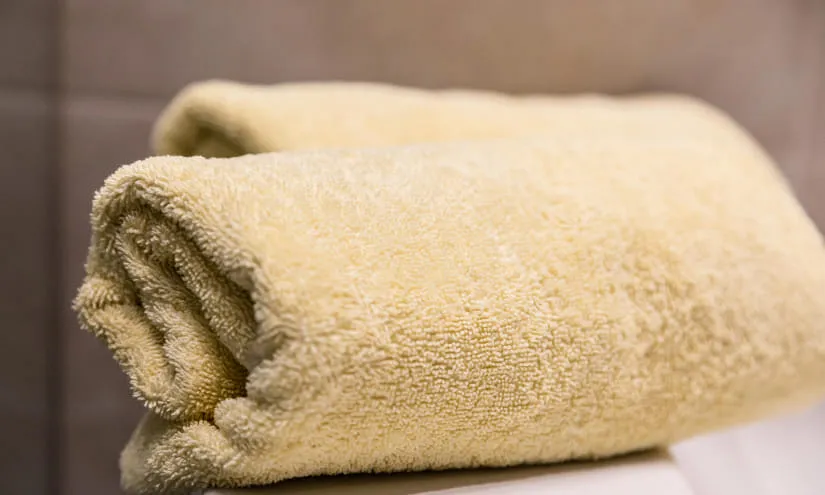 Gefaltete gelbe Handtücher auf einem Tisch