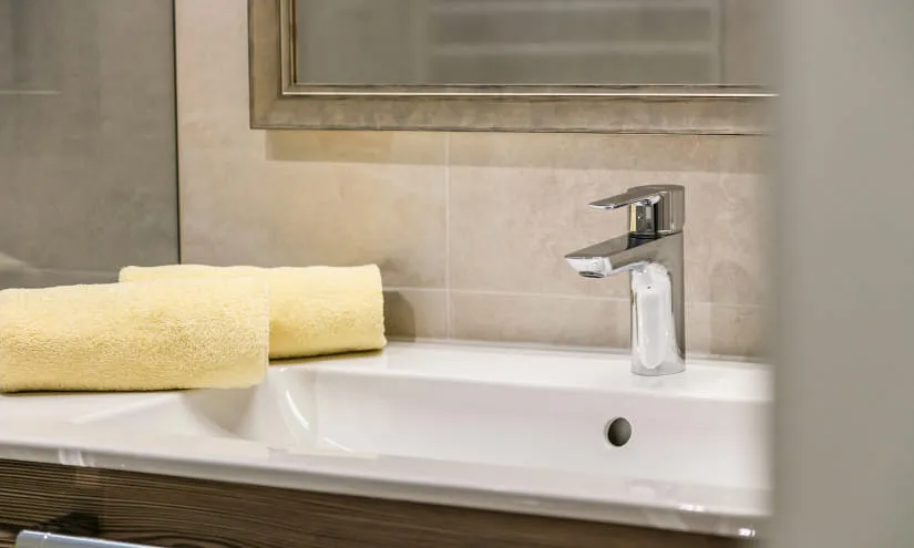 Badezimmer mit gelbem Handtuch und moderner Armatur