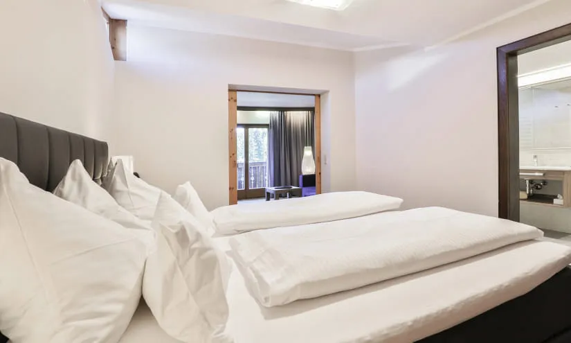 Helles Schlafzimmer mit Bett und Zugang zum Bad