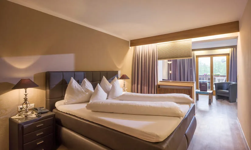 Modernes Hotelzimmer mit Doppelbett und Balkon