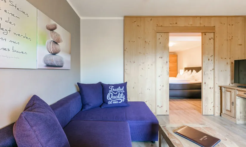 Gemütliches Zimmer mit Sofa und Holzverkleidung.
